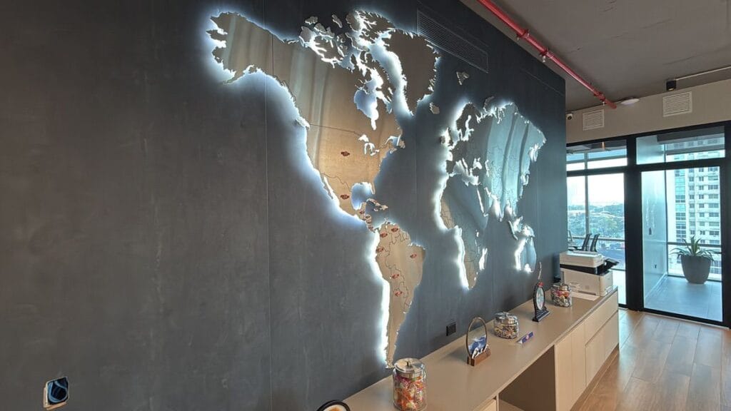 Mapa mundial iluminado en la pared de las oficinas de Candies Supplier destacando la presencia global.